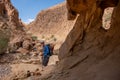 Male hiker going through a narrow deep canyon of dry wadi Abuv in Judean Desert close to city Arad, Israel.