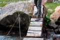 Legs of hiker on narrow wooden bridge over mountain river Royalty Free Stock Photo