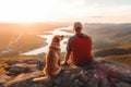 Male hiker and his pet dog admiring a scenic view from a mountain top. Adventurous young man with a backpack. Hiking and trekking Royalty Free Stock Photo