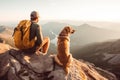 Male hiker and his pet dog admiring a scenic view from a mountain top. Adventurous young man with a backpack. Hiking and trekking Royalty Free Stock Photo