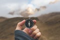 A male Hiker is looking for a direction with a magnetic compass in the mountains in the fall. Point of view shot. Man`s Royalty Free Stock Photo