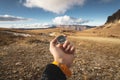 A male Hiker is looking for a direction with a magnetic compass in the mountains in the fall. Point of view shot. Man`s Royalty Free Stock Photo