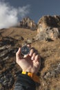 A male Hiker is looking for a direction with a magnetic compass in the mountains in the fall. Point of view shot. Man`s Royalty Free Stock Photo