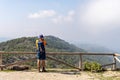 Male hiker observing a mountainous landscape near a wooden railing