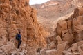 Male hiker posing inside a narrow deep canyon of dry wadi Abuv in Judean Desert close to city Arad, Israel.