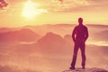 Man is stand on edge and enjoying dramatic overlook of misty landscape Royalty Free Stock Photo