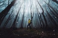 Male hiker standing in dark forest - Man with backpack walking in mystery woodland - Traveler in nature, courage, risk and success Royalty Free Stock Photo