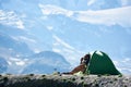 Traveler talking on radio while resting in mountains.