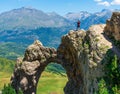Male hiker on the top of a natural rock arch. Active lifestyle concept