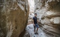 Male Hiker walks through desert slot canyon