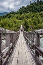 A male hiker on a wooden bridge over a river in Chile.