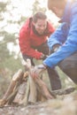 Male hikers lighting bonfire in forest