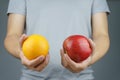 Male holding the apple in one hand and orange in another hand. It is a vegetarian and vegan food concept Royalty Free Stock Photo