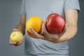 Male holding the apple and orange in one hand, and pear in another hand. It is a vegetarian and vegan food concept Royalty Free Stock Photo