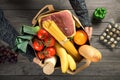 Male holding brown paper bag full of different healthy food