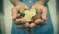 Male holding money gold coins in her hand for financial