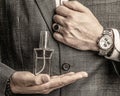 Male holding up bottle perfume. Hand in with wrist watch in a business suit. Perfume or cologne bottle and perfumery