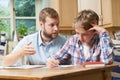 Male Home Tutor Helping Boy With Studies