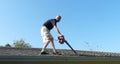 Male Homeowner Blowing Leaves from Gutter Royalty Free Stock Photo