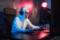 Male hooded gamer playing online game on pc computer