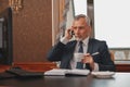 Male hotelier works at a computer and talking phone while sitting in his office in hotel Royalty Free Stock Photo