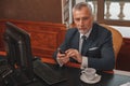 Male hotelier works at a computer and using phone while sitting in his office in hotel Royalty Free Stock Photo
