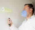Male house painter worker painting and priming wall with painting roller Royalty Free Stock Photo