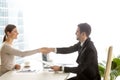 Businesswoman handshaking with businessman at desk Royalty Free Stock Photo