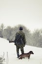 Male hunter with a dog in the forest in winter Royalty Free Stock Photo