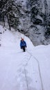 Male ice climber on a frozen ice fall covered in deep snow