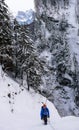 Male ice climber on a frozen ice fall covered in deep snow