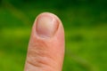 Male index finger close up on green background. Teen nail macro