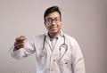 Male indian doctor in white coat and stethoscope showing money sign Royalty Free Stock Photo