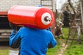 A male industrial worker walks with a gas cylinder to a gas car. Transportation and installation of a propane bottle to