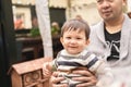 Male infant smiling sitting on his father\'s legs looking at camera, dad is holding baby with his hands. Royalty Free Stock Photo