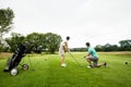 Male instructor assisting woman in learning golf