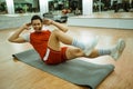 male instructor doing bicycle crunches on a mat Royalty Free Stock Photo