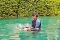 Male instructor swimming for children teaches a happy boy to swim in the pool Royalty Free Stock Photo