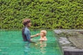 Male instructor swimming for children teaches a happy boy to swim in the pool Royalty Free Stock Photo