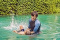 Male instructor swimming for children teaches a happy boy to swim in the pool Royalty Free Stock Photo