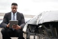 Male Insurance Loss Adjuster With Digital Tablet Inspecting Damage To Car From Motor Accident Royalty Free Stock Photo