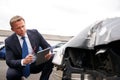 Male Insurance Loss Adjuster With Digital Tablet Inspecting Damage To Car From Motor Accident Royalty Free Stock Photo