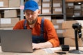 Male inventory manager or worker checks stock, using a laptop computer. Millennial man working in a warehouse with Royalty Free Stock Photo