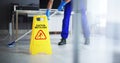 Male Janitor Cleaning Floor With Caution Wet Floor Sign Royalty Free Stock Photo