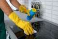 Male janitor cleaning kitchen stove with sponge Royalty Free Stock Photo