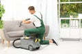 Male janitor removing dirt from sofa