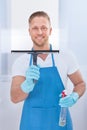 Male janitor using a squeegee to clean a window Royalty Free Stock Photo
