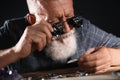 Male jeweler evaluating brooch in workshop, closeup view