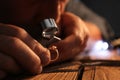 Male jeweler evaluating diamond ring, closeup view