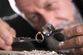 Male jeweler evaluating diamond ring in workshop, closeup